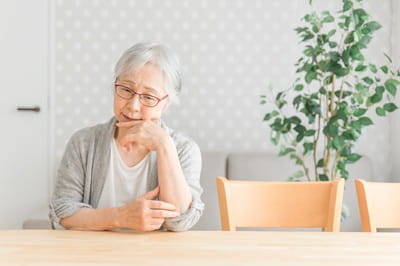 憂鬱な表情の高齢者女性の写真
